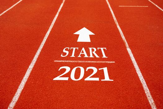 Start line to 2021 on running court represents the beginning of a journey to the destination in business planning, strategy and challenge or career path, opportunity concept.