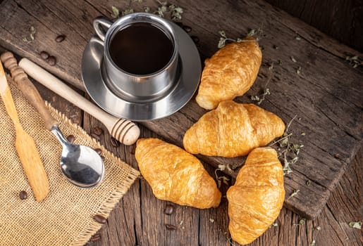 Coffee and croissants on the black wooden background, top view