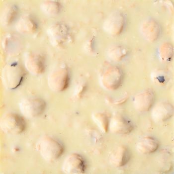 White chocolate with whole almond nuts top view background.