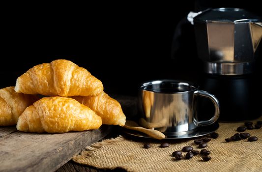 Coffee and croissants on the wooden background, top view