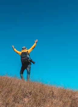 Silhouette of man hold up hands on the peak of mountain
