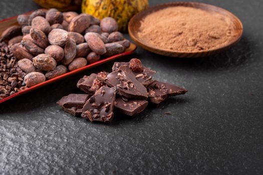 Cocoa beans and cocoa pod on a wooden surface.