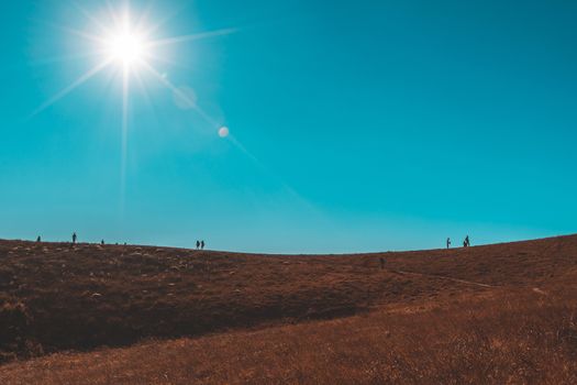 Silhouette of man hold up hands on the peak of mountain
