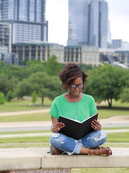 Beautiful African American woman reading a book, background Austin, Texas