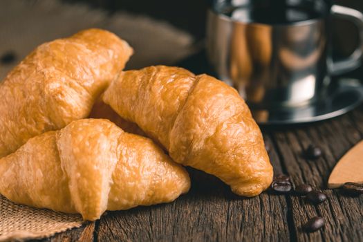 Coffee and croissants on the wooden background, top view