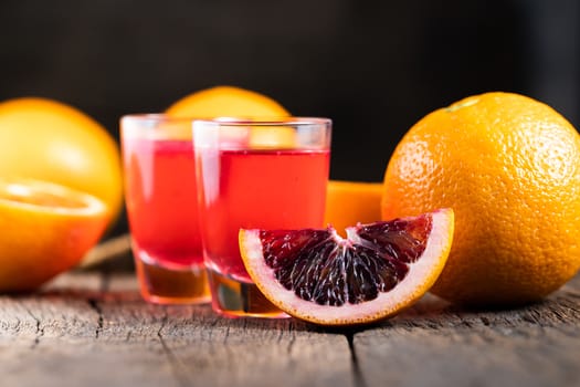 Sliced Sicilian Blood oranges fruits over old dark wooden background. Top view.