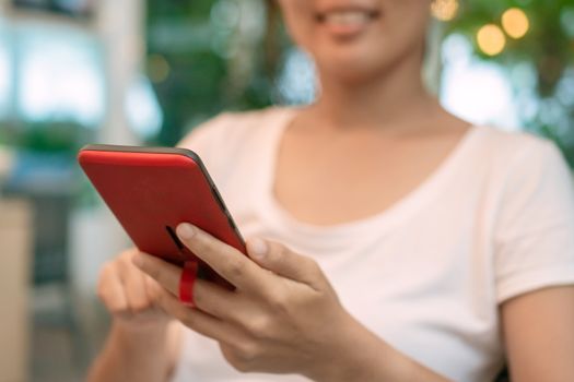 Woman hand use smartphone to do work business, social network, communication in public cafe work space area.