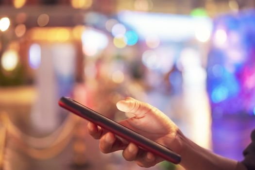 Woman hand use smartphone to do work business, social network, communication in public cafe work space area.