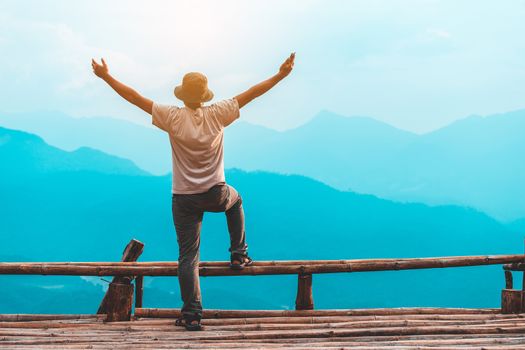 Silhouette of man hold up hands on the peak of mountain