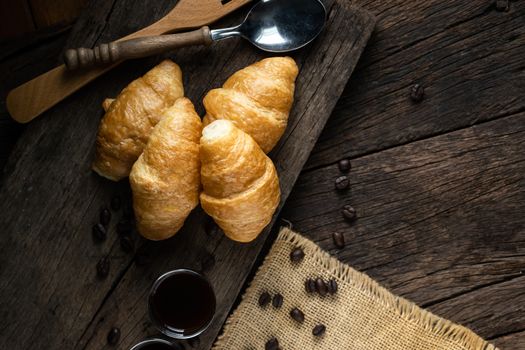 Coffee and croissants on the wooden background, top view