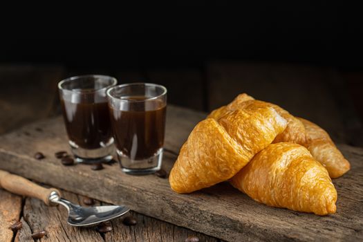 Coffee and croissants on the  wooden background, top view