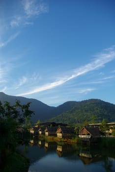 In the morning light small huts beside the lake and the mountain view