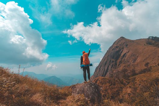 Silhouette of man hold up hands on the peak of mountain,success concept