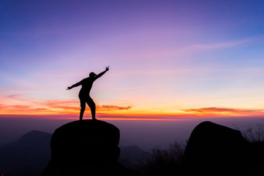 travels Silhouette on the peak of mountain,success concept