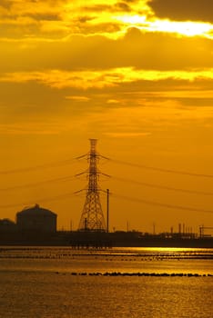 Coastal industrial estates and the hight voltage power line in the evening sunlight