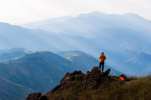 Silhouette of man hold up hands on the peak of mountain,success concept