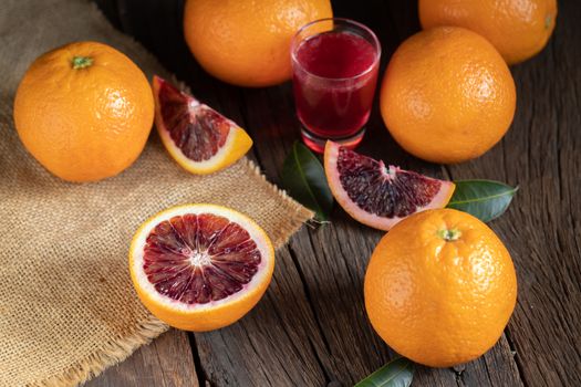 Sliced Sicilian Blood oranges fruits over old dark wooden background. Top view.