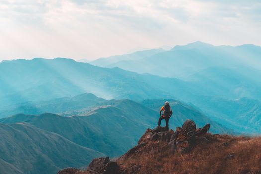 Silhouette of man hold up hands on the peak of mountain,success concept