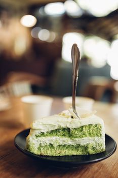 green cake in white plate on wooden table background