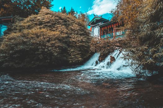 Beautiful view of the Jade Dragon Snow Mountain and the Suocui Bridge over the Black Dragon Pool in the Jade Spring Park, Lijiang, Yunnan