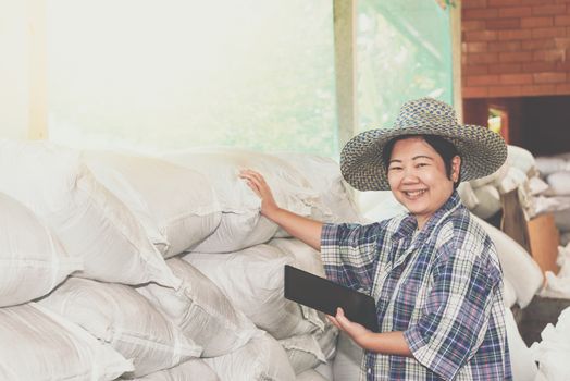 Asian woman smart farmer agriculturist happy at a Fertilizer composting plant with Organic Fertilizer, Compost (Aerobic Microorganisms) from animal waste for use in the organic agriculture industry