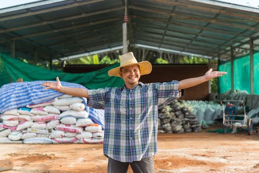 Asian man farmer agriculturist happy at a Fertilizer composting plant with Organic Fertilizer, Compost (Aerobic Microorganisms) from animal waste for use in the organic agriculture industry