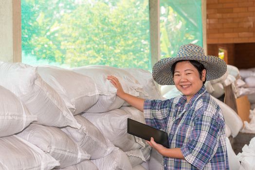 Asian woman smart farmer agriculturist happy at a Fertilizer composting plant with Organic Fertilizer, Compost (Aerobic Microorganisms) from animal waste for use in the organic agriculture industry