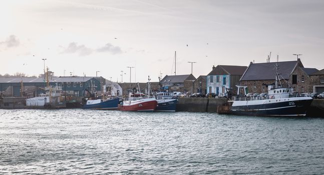 Howth near Dublin, Ireland - February 15, 2019: view of the fishing port of the city where are parked professional fishing boats on a winter day