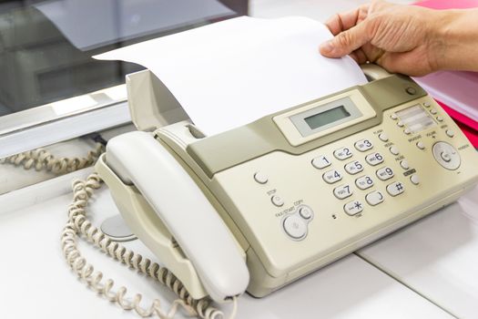 hand man are using a fax machine in the office, equipment for data transmission.