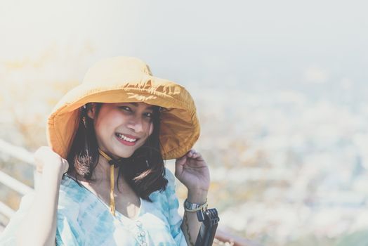 Asian pretty cute woman with hat relax at seaside city landscape viewpoint on mountain with happy and freedom emotion in concept travel, vacation, leisure in life