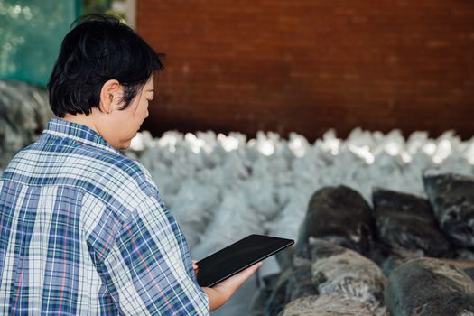 Asian woman smart farmer agriculturist working at Fertilizer composting plant with Organic Fertilizer, Compost (Aerobic Microorganisms) from animal waste for use in the organic agriculture industry