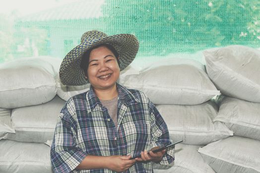 Asian woman smart farmer agriculturist happy at a Fertilizer composting plant with Organic Fertilizer, Compost (Aerobic Microorganisms) from animal waste for use in the organic agriculture industry