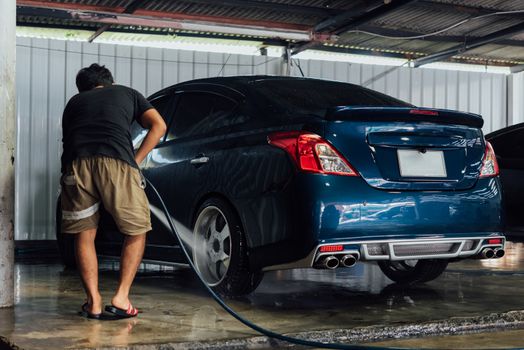 Car care staff cleaning (clean, wash, polish and wax) the car (Car detailing) at car care shop in Bangkok Thailand