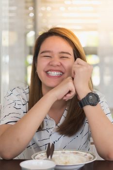 Asian pretty cute woman eating thai food with rice and many food on dining table in restaurant with happy and enjoy emotion