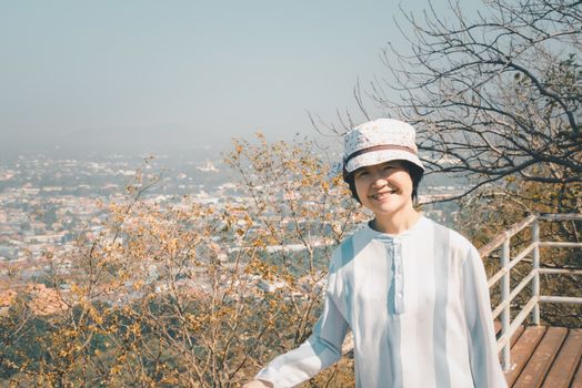 Asian pretty cute woman with hat relax at seaside city landscape viewpoint on mountain with happy and freedom emotion in concept travel, vacation, leisure in life