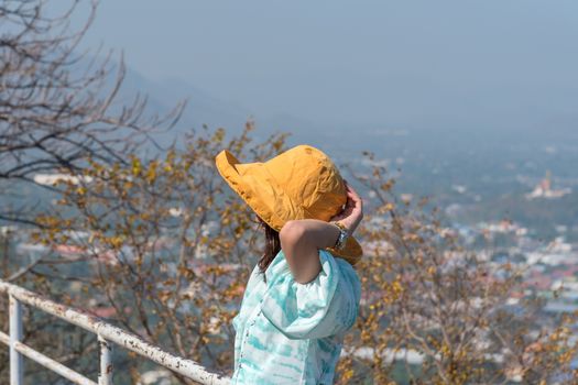 Asian pretty cute woman with hat relax at seaside city landscape viewpoint on mountain with happy and freedom emotion in concept travel, vacation, leisure in life