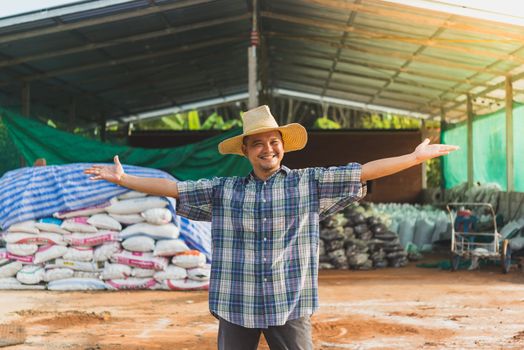 Asian man farmer agriculturist happy at a Fertilizer composting plant with Organic Fertilizer, Compost (Aerobic Microorganisms) from animal waste for use in the organic agriculture industry