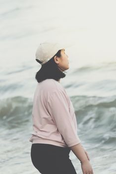 Asian woman relax at sea beach with loneliness and lonely emotion in concept travel, vacation, leisure in life