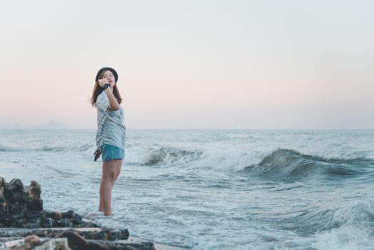 Asian pretty cute woman relax at sea beach with happy and freedom emotion in concept travel, vacation, leisure, fun in life