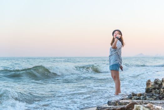 Asian pretty cute woman relax at sea beach with happy and freedom emotion in concept travel, vacation, leisure, fun in life