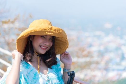 Asian pretty cute woman with hat relax at seaside city landscape viewpoint on mountain with happy and freedom emotion in concept travel, vacation, leisure in life