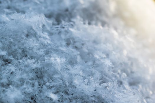 Macro background of fresh snowflake texture on a blur.