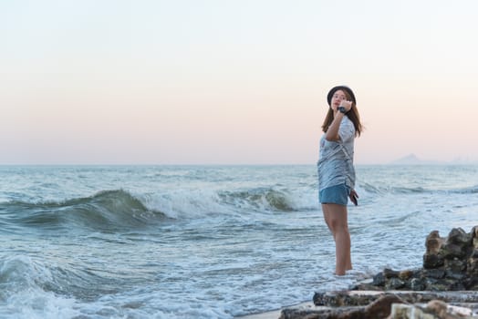 Asian pretty cute woman relax at sea beach with happy and freedom emotion in concept travel, vacation, leisure, fun in life