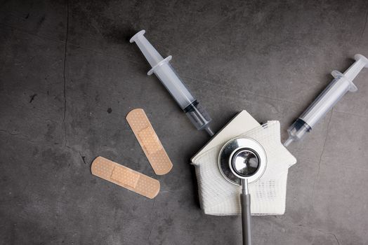 Wooden model white houses and first aid equipment on a cement gray background. Concept home repair, Home improvement, Renovate home.