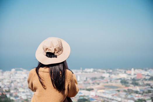 Asian pretty cute woman with hat relax at seaside city landscape viewpoint on mountain with happy and freedom emotion in concept travel, vacation, leisure in life
