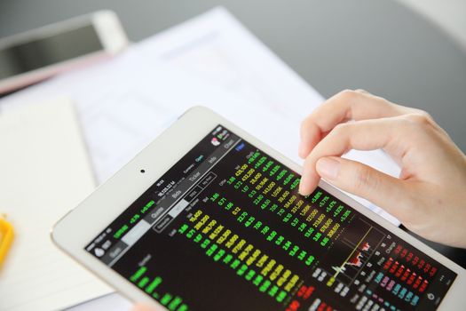 Woman hand Trading online on tablet with business paper and coffee