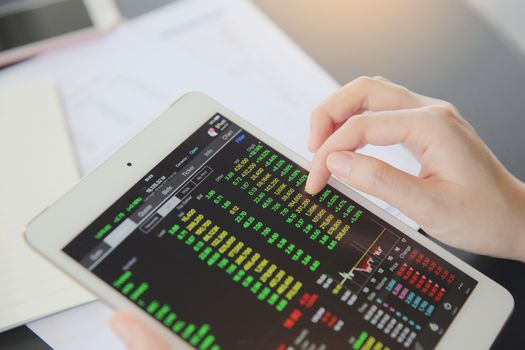 Woman hand Trading online on tablet with business paper and coffee