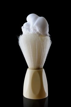 A shaving brush with shaving cream. isolated on black background