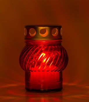 A red glass tea light with a candle inside to illuminate the Xmas night and other celebrations