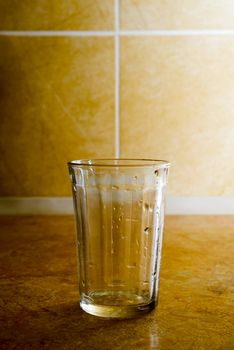 Empty glass with water drops in the kitchen